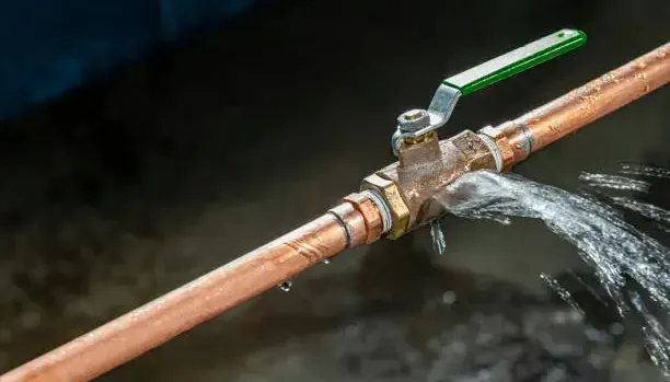 Water spraying from a failed valve on a copper supply pipe